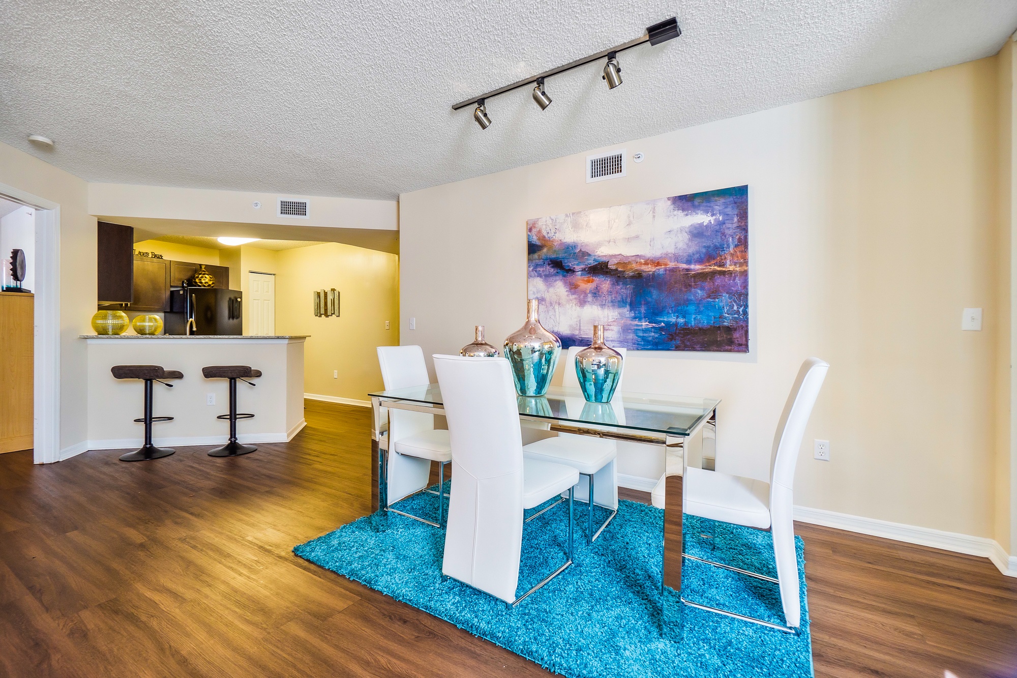 A dining room with a glass table and chairs.